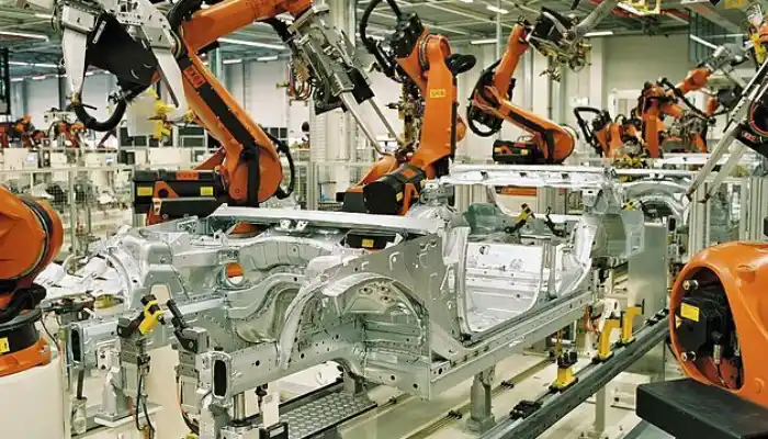 An industrial automation showcase tailored for Automotive Industries by Grow Factor LLC, displaying a highly modern vehicle assembly line factory where orange robotic mechanical arms are manufacturing and welding a silver metal car body chassis on an automated conveyor track.